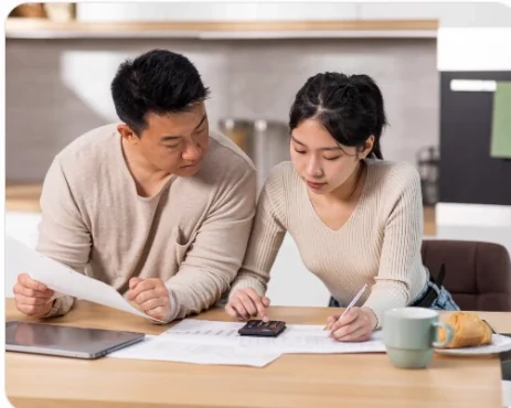 A couple reviewing their spending and savings plan together at a kitchen table