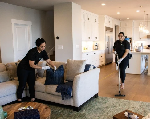 Professional cleaners preparing a living room for holiday guests
