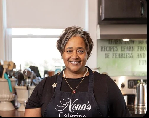 A food business owner standing in her kitchen